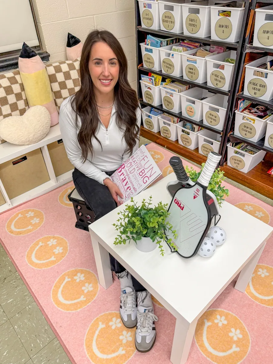 Brittany Sikoryak, founder of Little Picklers, in her classroom with a pickleball paddle and a 'Play big, have fun' sign